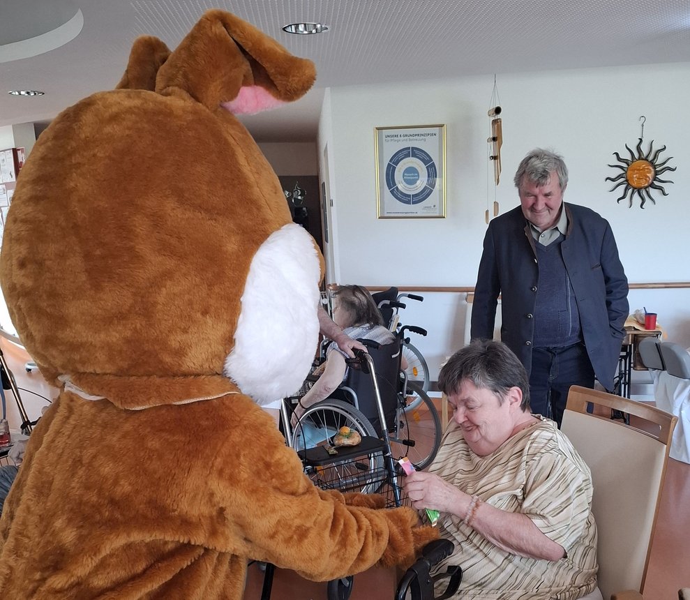 Herr Haider sieht, mit welcher Freude Frau Stickelberger die Gaben vom Osterhasen in Empfang nimmt.